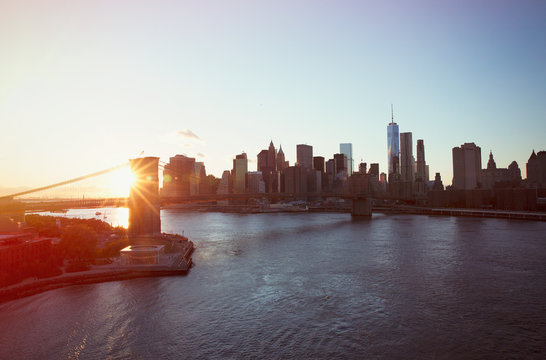 Cityscape view of New York and Brooklyn Bridge at sunset