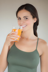 Giovane donna con bicchiere di succo di arancia