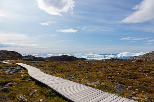 Footpath leading toward icebergs on remote coastline Greenland