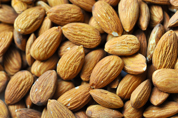 Background of big raw peeled almonds situated arbitrarily. Almonds background