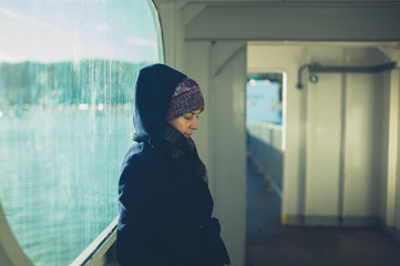 Young woman leaning against window on ferry
