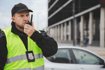 Proud policemen speaking on the walkie-talkie, reporting to station