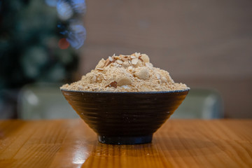Closeup hojicha Bingsu on tray, Bingsu or Bingsoo, Korean shaved ice dessert with sweet toppings and fruit and varieties with ingredients, popular dessert, using as a background or wallpaper
