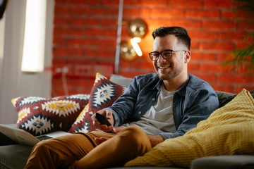 Young man watching tv at home.