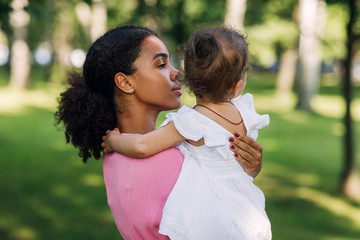 Obraz premium Mixed race woman holding her little daughter on hands
