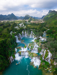Massive hidden waterfall surrounded by mountain with blue clean water. Paradise on the border between China and Vietnam. Ban gioc waterfall, Detian. - obrazy, fototapety, plakaty