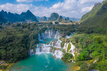 Massive hidden waterfall surrounded by mountain with blue clean water. Paradise on the border between China and Vietnam. Ban gioc waterfall, Detian.