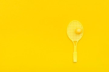 Tennis racket and ball sports on yellow background.