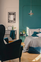 Copy space on empty green wall of elegant bedroom interior