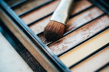 Eyeshadow palette in beige colors with makeup brush
