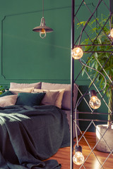 Beautiful bedroom interior with green design, copy space on empty wall