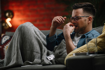 Obraz premium Sick man at home. Man taking medicine. 