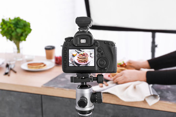 Tasty pancakes on display of professional photo camera in studio