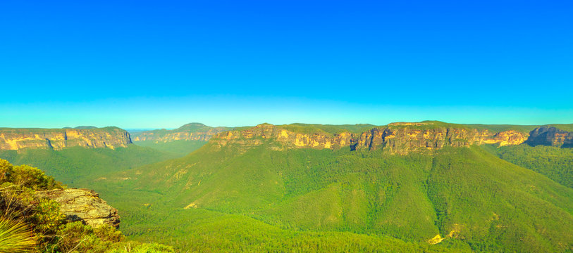 Banner panorama of canyon and rock formations of Blue Mountains National Park landscape in New South Wales, Australia. Blue sky with copy space.