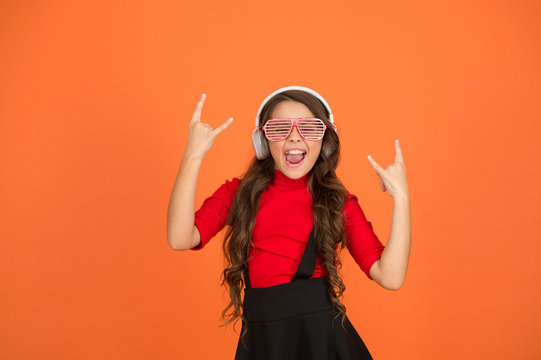 Cool track. Event and entertainment. Party girl. Party accessory. Having fun. Play list for party. Music concept. Kid wear eyeglasses. Eyewear fashion store. Girl with eyeglasses orange background