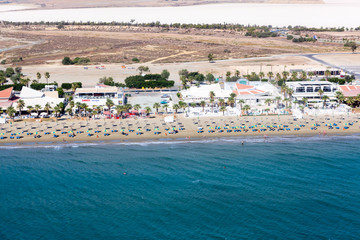 Aerial view at Mackenzie beach with hotel and apartment buildings, sunbeds and umbrellas. It is the beach close to Larnaca International Airport on south of island. Cyprus