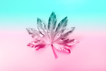 Beautiful Leaf painted in golden and copper metallic paint on pink background. Duotine image, top view, copy space, flat lay