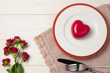Dessert mousse in the shape of a pink glazed heart with a rose, for Valentine's Day. Flat lay