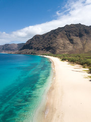 Man walking on the beach - Tropical paradise beach with white sand and mountain background travel tourism wide panorama background. Hawaiian beach. Oahu.