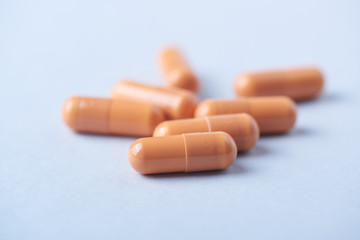 HMB (β-Hydroxy β-methylbutyric acid) capsules. Bodybuilding food supplements on bright paper background. Close up. 