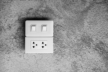 white lighting switch and socket electric at concrete wall. - saving and installation concept.