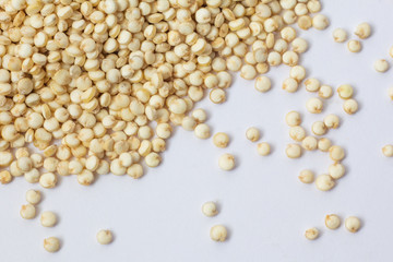semillas crudas de quinoa en fondo blanco