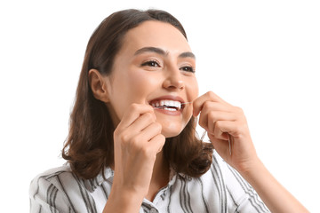Fototapeta premium Beautiful young woman with dental floss on white background