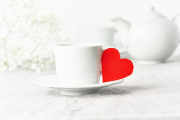 Valentine's Day. Morning breakfast for two with tea and flowers. Red felt heart is symbol of lovers