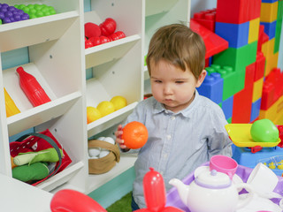 A child plays with toys at home. Little child plays with toys in kindergarten.