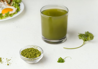 Matcha green tea next to fried eggs and vegetables. healthy breakfast concept