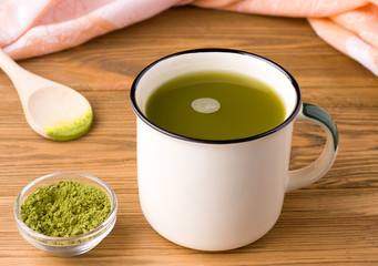 green matcha tea on a wooden table in a mug. rustic concept