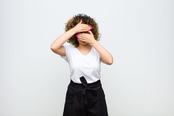 young pretty woman covering face with both hands saying no to the camera! refusing pictures or...