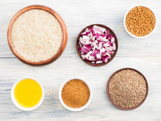 Ingredients for cooking basmati rice: butter, cumin (jeera), fenugreek, masala, red onion. Healthy eating concept