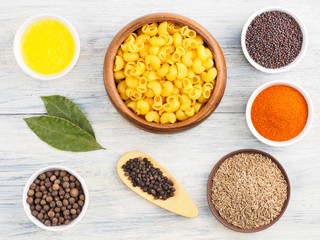 Ingredients for cooking pasta: butter, salt, cumin (jeera), red chili pepper, mustard seeds, bay leaves, black pepper. Healthy eating concept