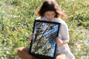Chica sujetando espejo en bosque