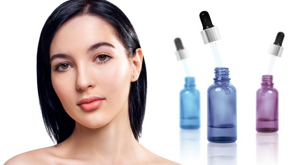 Cosmetics oil in bottles near beautiful face of young brunette woman.