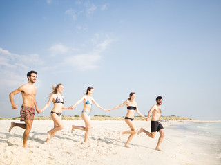 Group of friends running to the water