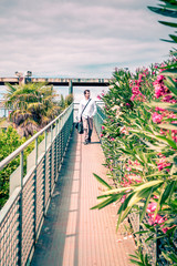relaxed man descending over a steel bridge between plants and flowers in a contemplative attitude