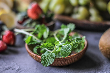 Obraz na płótnie Canvas Photo of fresh mint leaves in a bowl. Mint and strawberry. Ingredients for summer cocktails and lemonade. Herb. Still life photography. Image