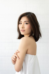 happy young Asian woman smiling crossing arms and standing over white wall background. Looking camera , she is very excited