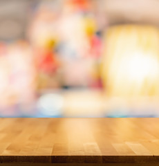 Empty brown wooden table and blur background of resturant lights ,can be used for montage or display your products with copy space ,business concept
