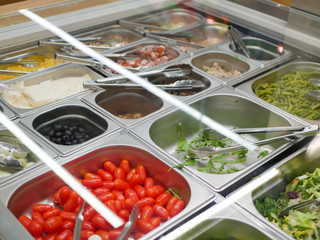 Vegetables by weight in iron dishes. in the mall. Vegetarian food.