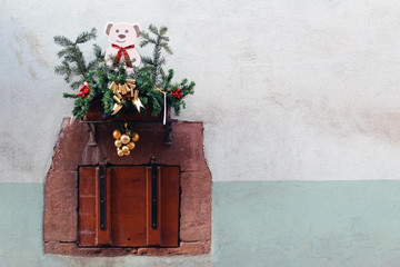 Old closed wooden small window with christmas decorations (pine tree and puppy)