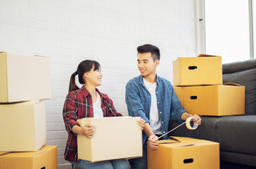 Young couple Asian man and woman Packing boxes and carrying large packed carton cardboard boxes on...