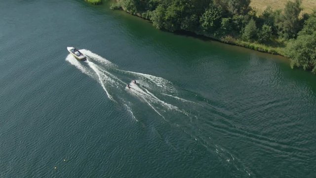 Aerial drone wakeboarding going into sun lake