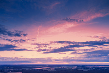 Aerial view of countryside in evening at sunset light. Beautiful nature landscape with cloudy sky