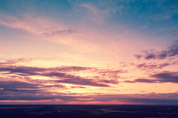 Aerial view of countryside in evening at sunset light. Beautiful nature landscape with cloudy sky