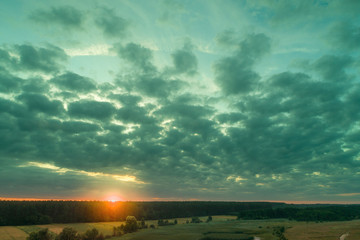 Aerial view of countryside in evening at sunset light. Beautiful nature landscape with cloudy sky
