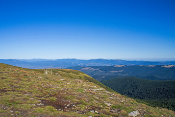 Colorful mountain landscape in the summer mountains. Large hills with blue sky.