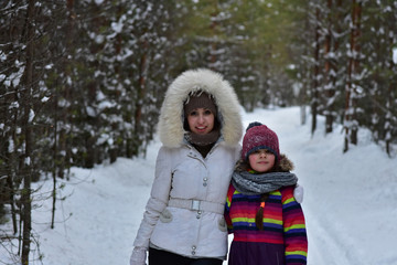 Mom with daughter in the January winter forest